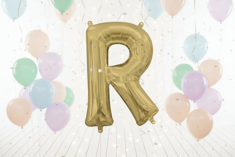Gold letter 'R' balloon against a white curtain background