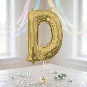 Gold letter 'D' balloon against a white background with colorful ribbons and confetti. - Party Centre