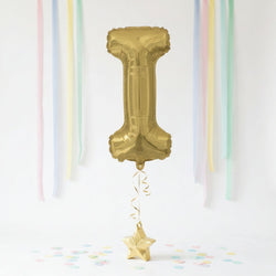 Gold number '1' balloon with decorative ribbons and confetti on a white background