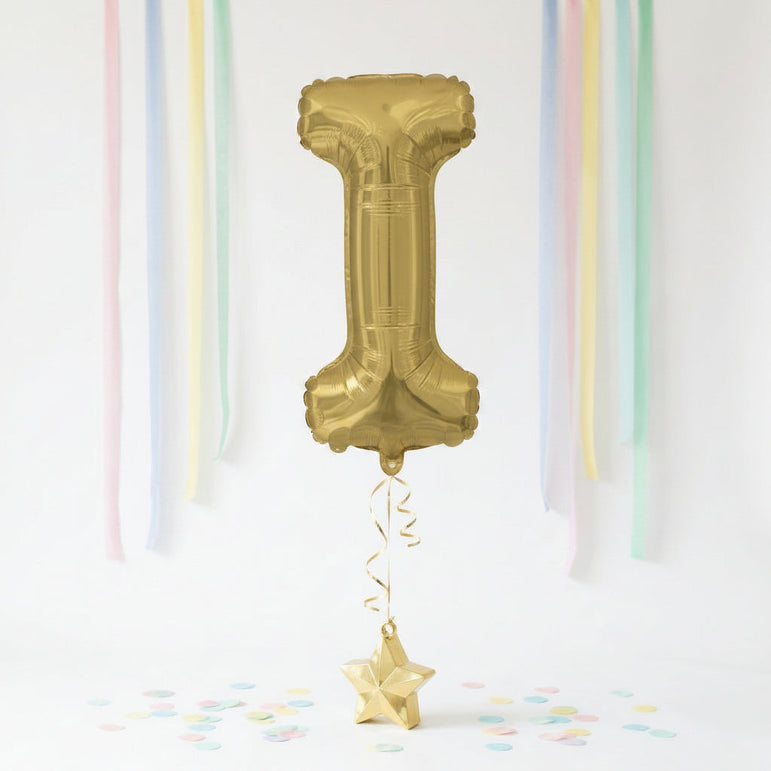 Gold number '1' balloon with decorative ribbons and confetti on a white background