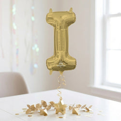 Gold number 1 balloon on a white surface with decorative elements
